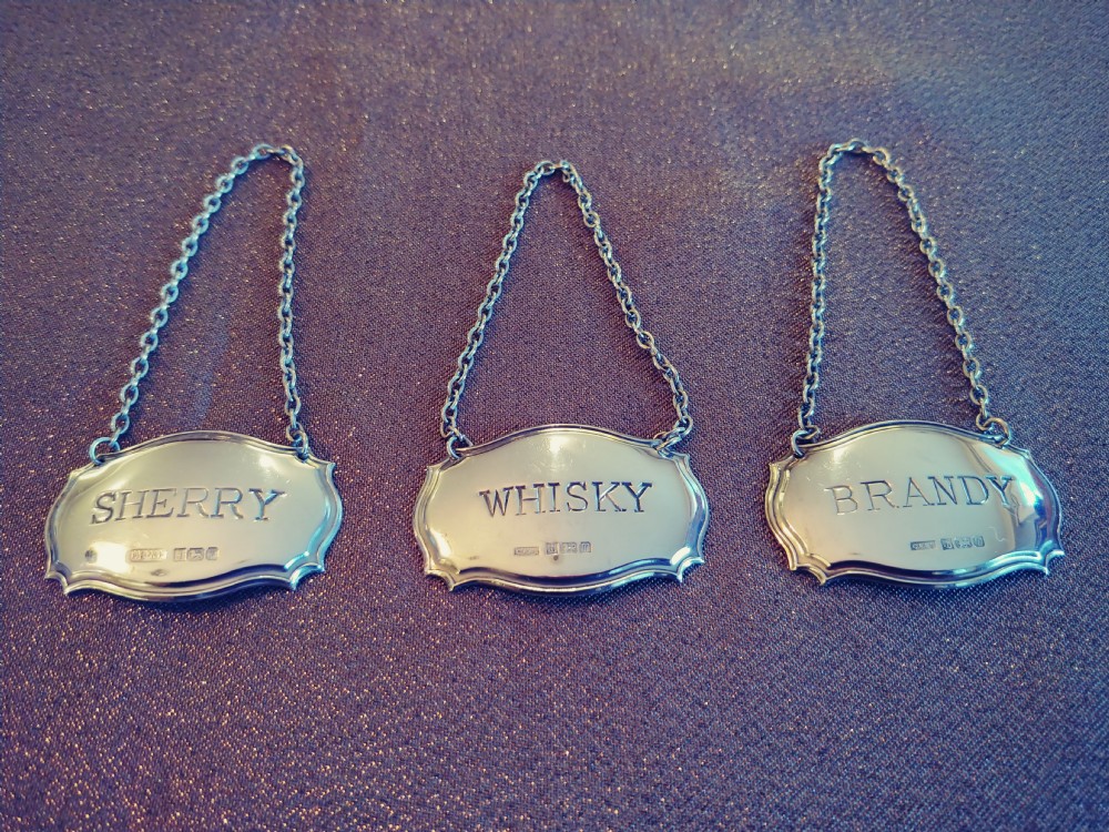 very nice set of three sterling silver matching decanter labels on silver chains